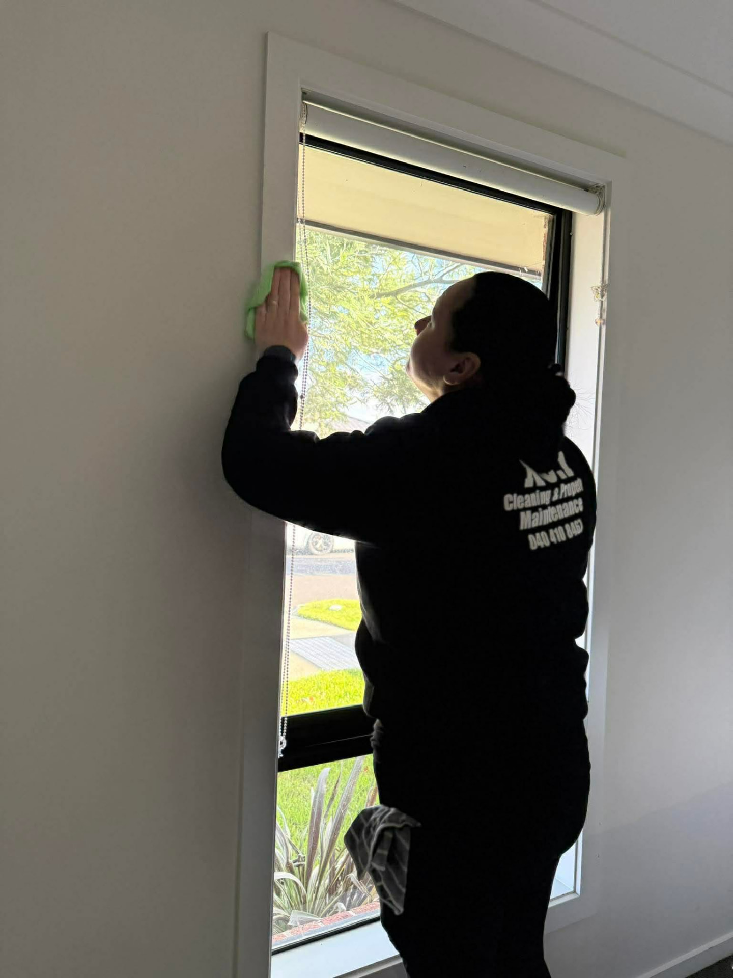 No.1 Cleaning team member wiping down window glass and frame with a microfibre cloth