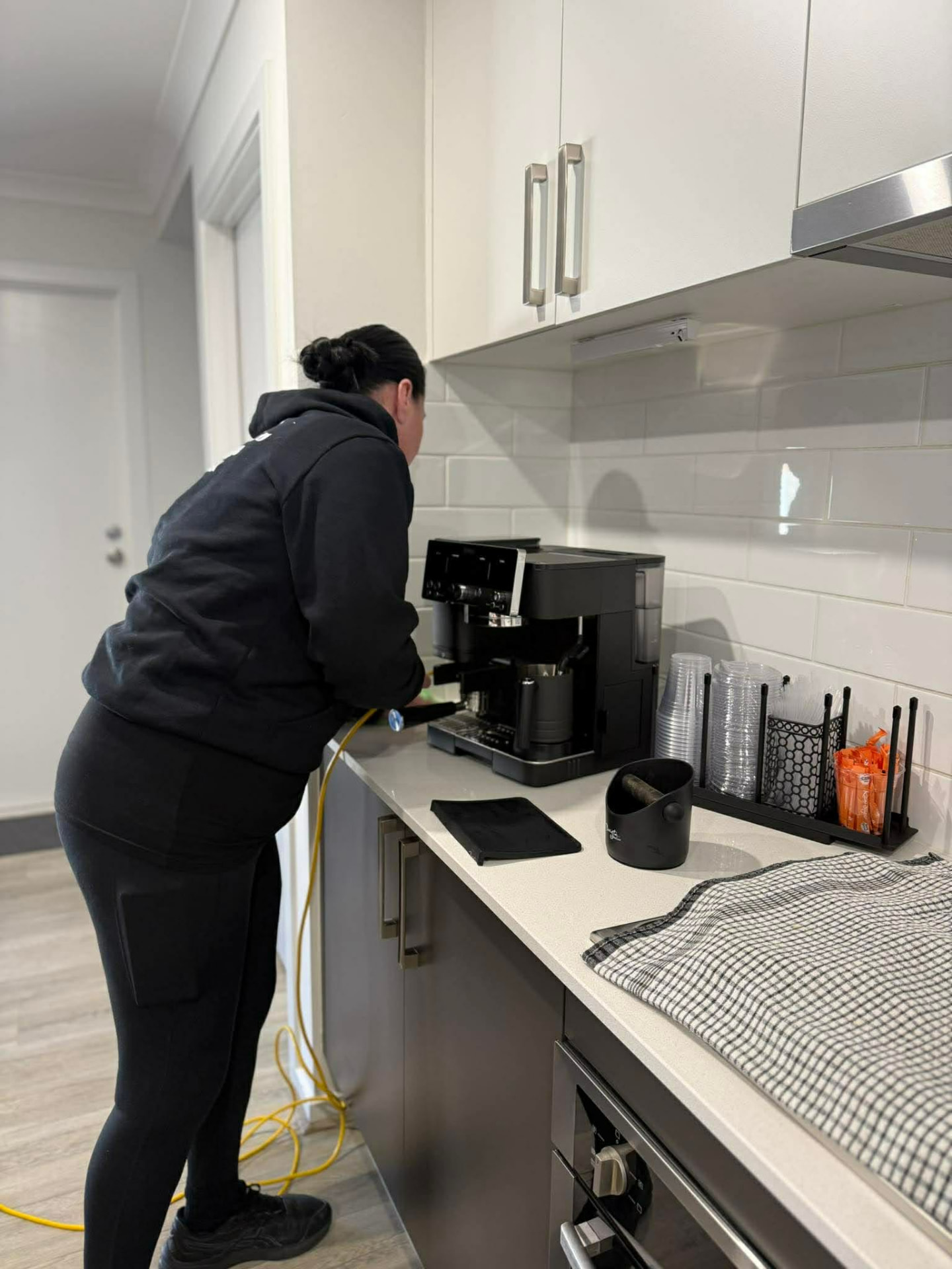 No.1 Cleaning team member wiping down a kitchen coffee machine during a regular clean