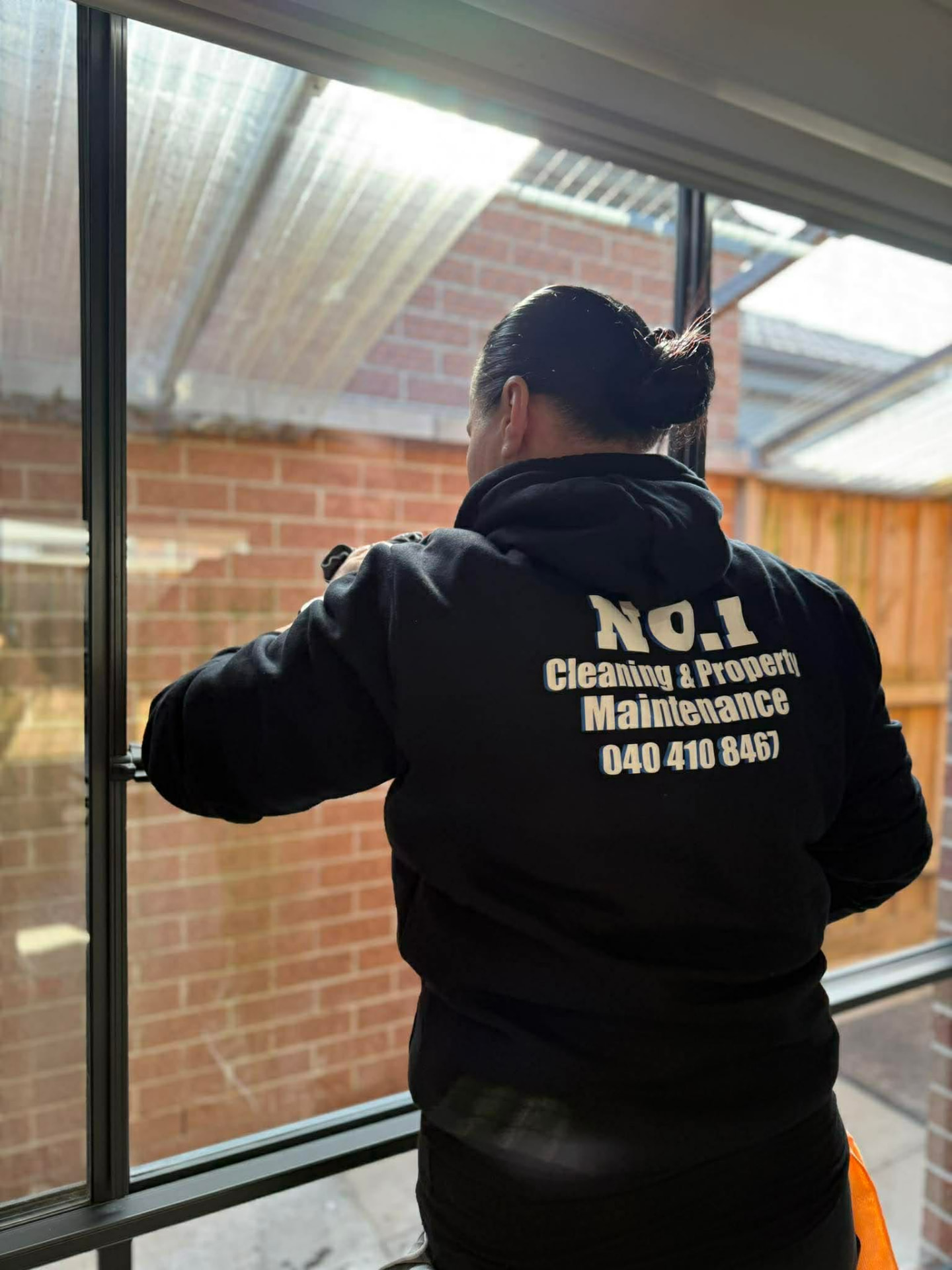 A No.1 Cleaning team member cleaning a window